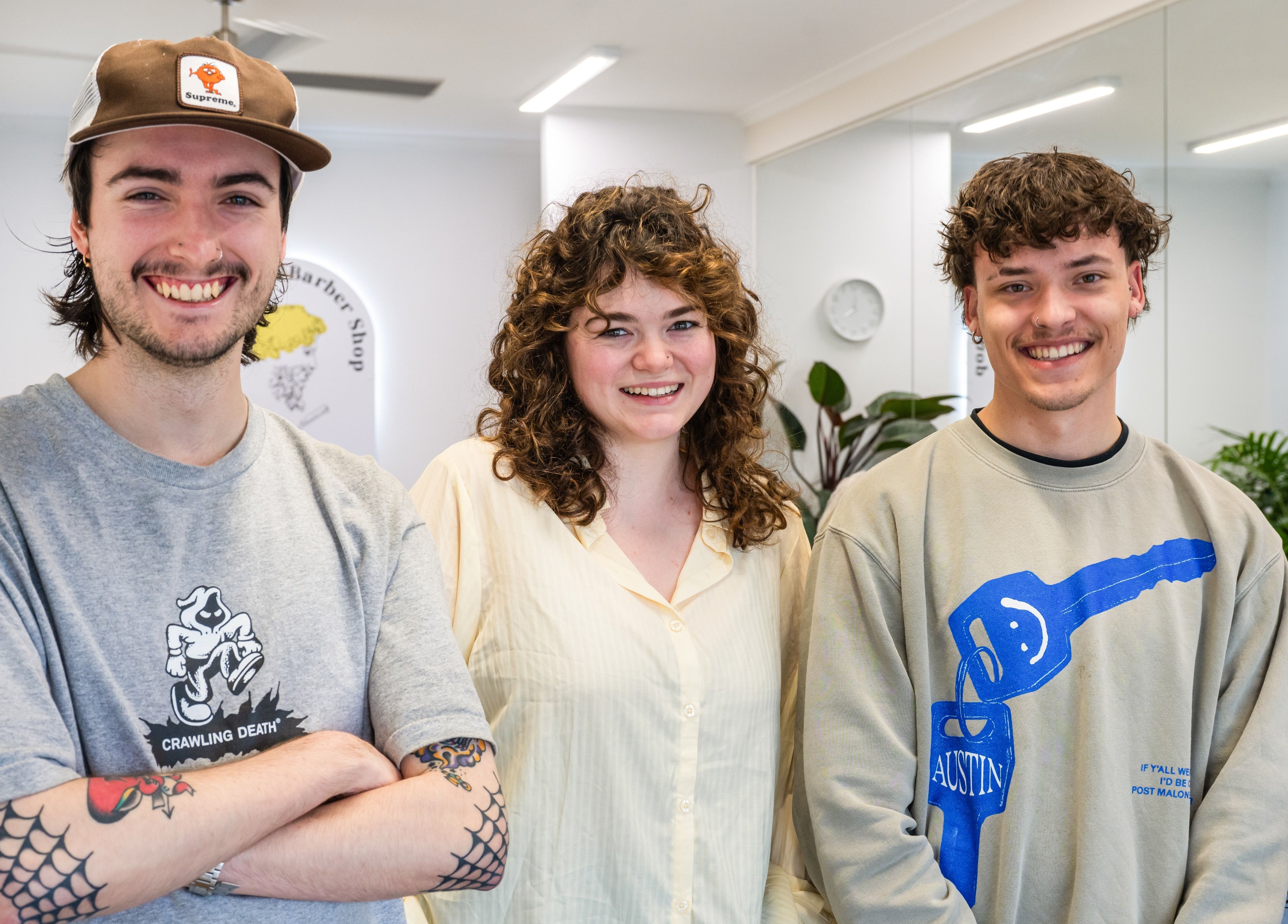 Friendly stylists at Ocean Grove Barbershop, Ocean Grove, VIC, AU, smiling in a modern setting.