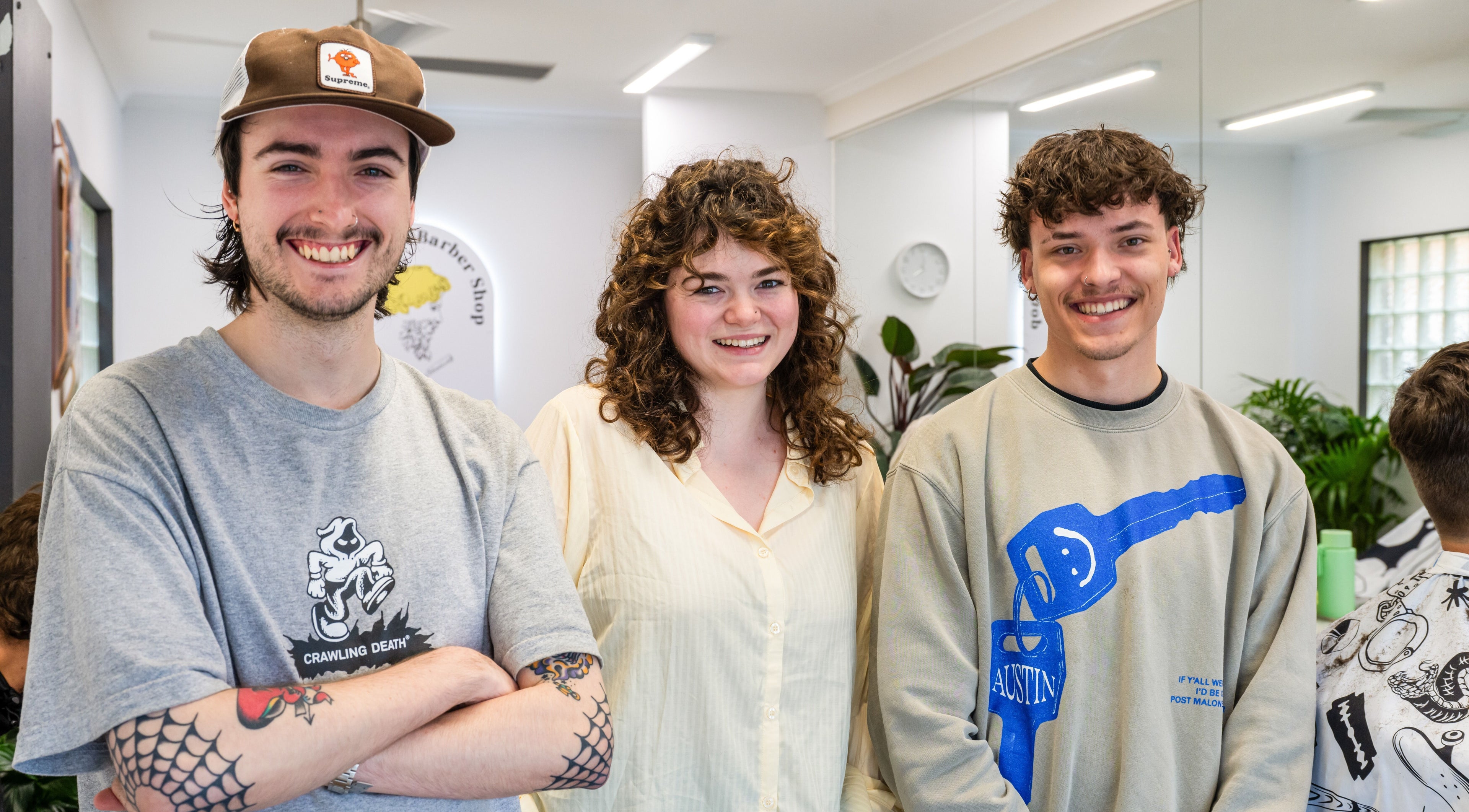 Friendly stylists at Ocean Grove Barbershop, Ocean Grove, VIC, AU, smiling in a modern setting.