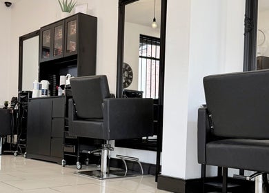 Stylish salon interior at Ivor Hairdressing, Stoke-on-Trent, England, GB, featuring modern black styling chairs.