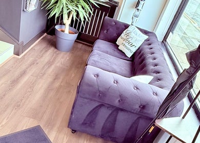 Inviting seating at Ivor Hairdressing in Stoke-on-Trent, England, GB, featuring a plush purple sofa.