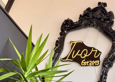 Elegant neon sign of Ivor Hairdressing, Est 2013 in ornate black frame at Stoke-on-Trent, England, GB.