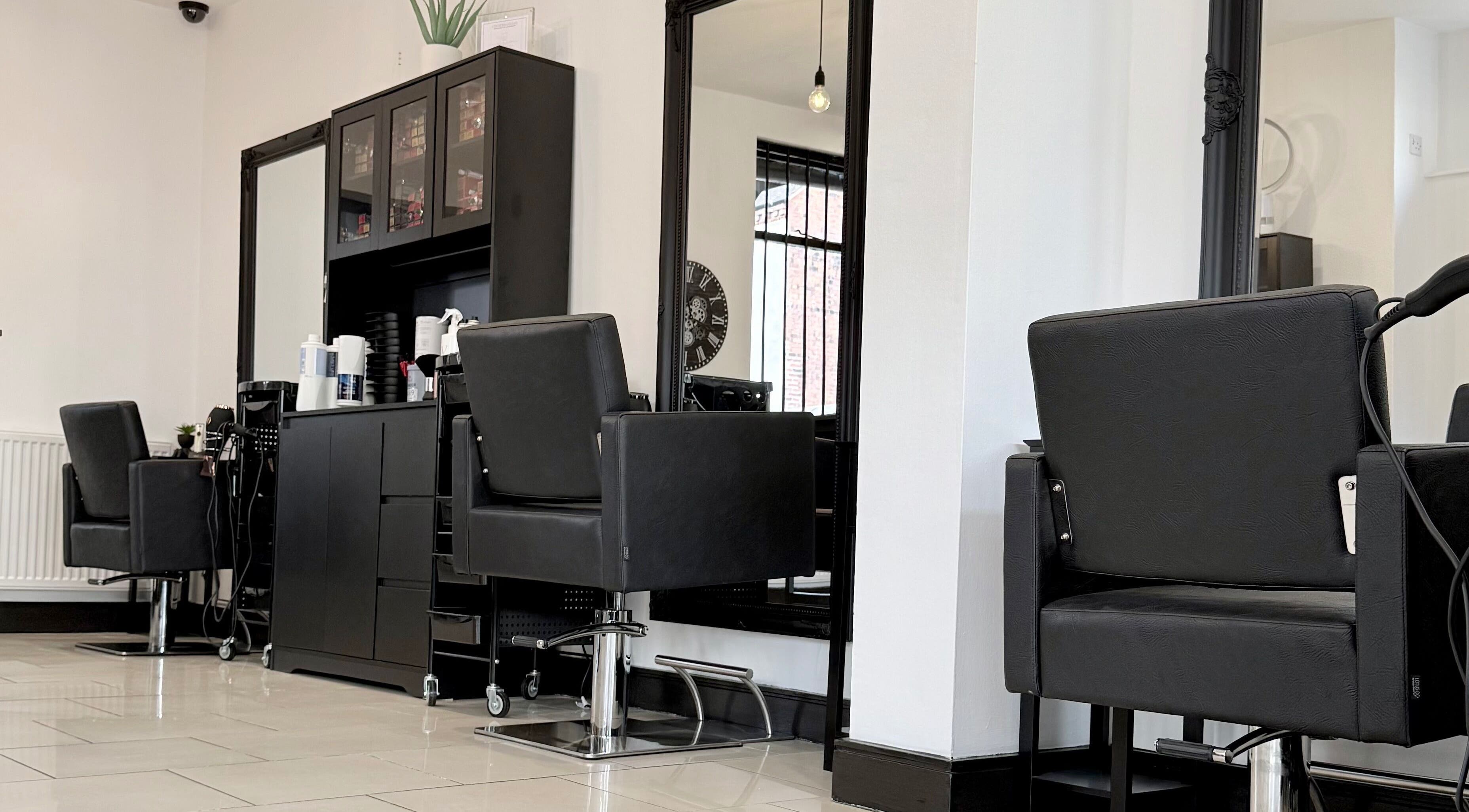 Modern salon chairs at Ivor Hairdressing in Stoke-on-Trent, England, GB with sleek black decor.