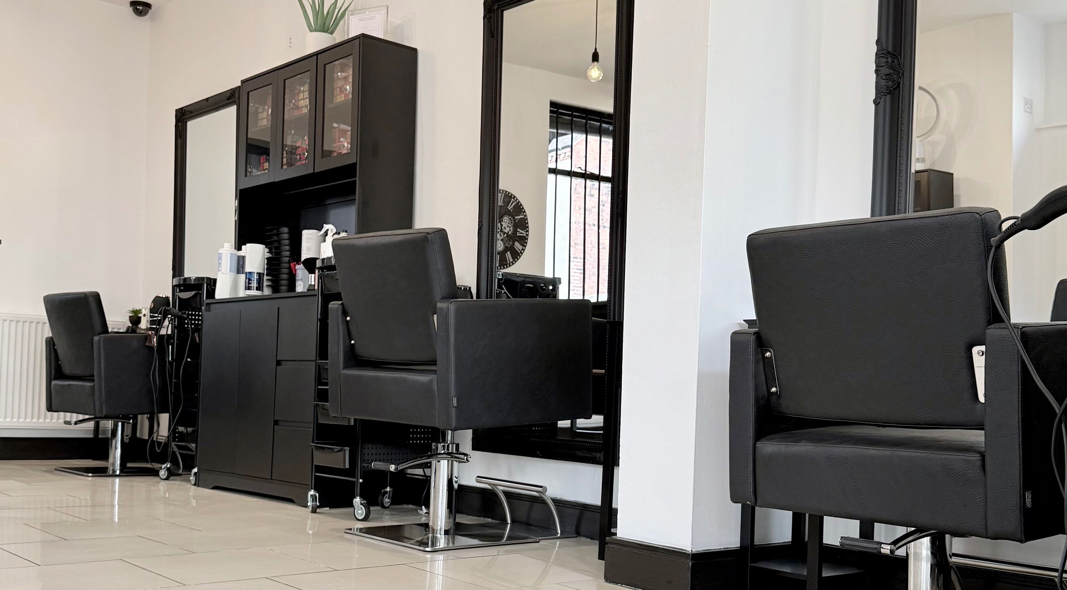 Modern salon chairs at Ivor Hairdressing in Stoke-on-Trent, England, GB with sleek black decor.