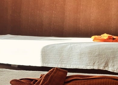 Tranquil massage room at Alam Wellness Bali in Denpasar, Bali, ID with white linens and warm lighting.