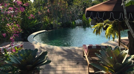 Peaceful poolside with lush greenery at Alam Wellness Bali in Denpasar, Bali, ID, offering serene relaxation.