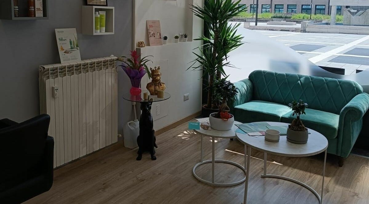 Sala d'attesa accogliente di DG Parrucchieri, Caronno Pertusella, Lombardia, IT, con divano verde e piante.