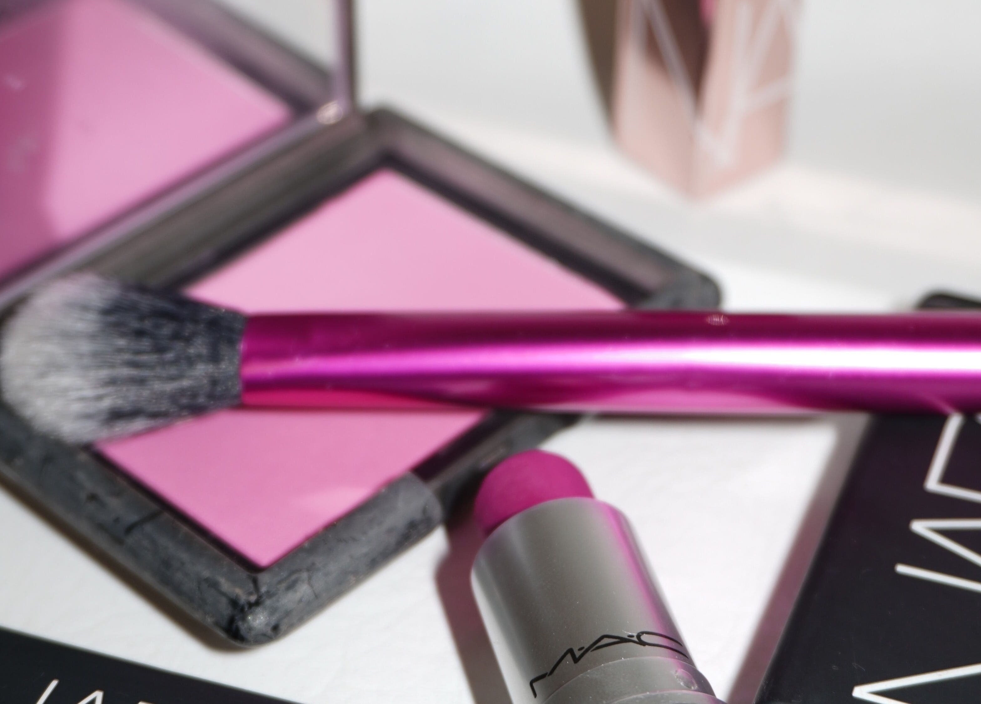 Vibrant pink makeup set at Touch, Royal Tunbridge Wells, England, GB showcasing brush and lipstick.