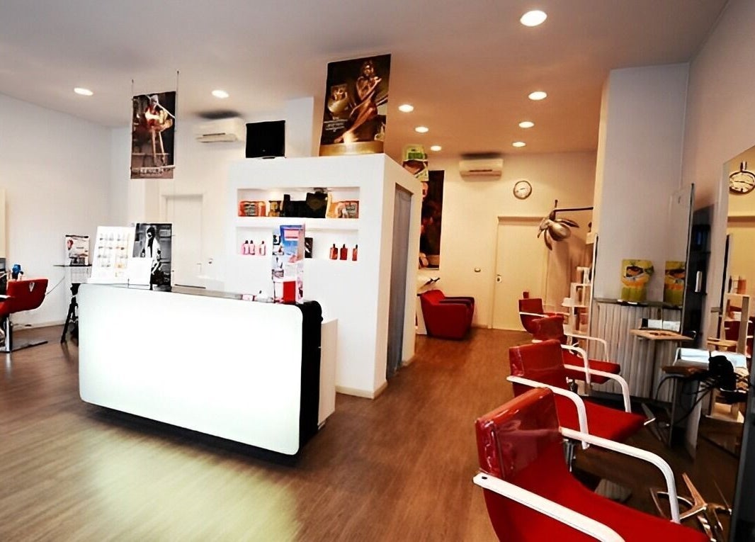 Interno moderno del salone Spazio uomo donna a Brescia, Lombardia, IT, con poltrone rosse e arredi eleganti.