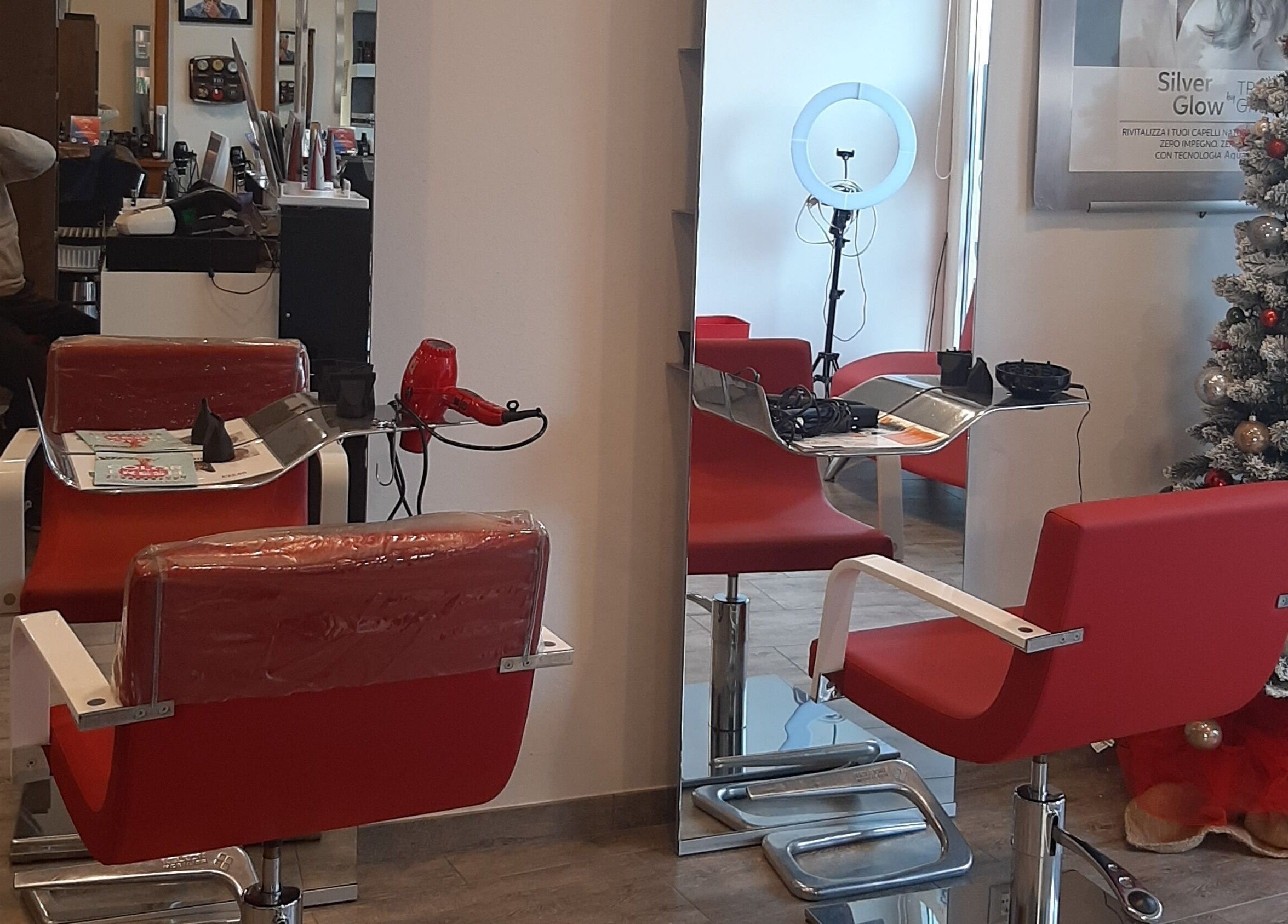 Interno del salone Spazio uomo donna con sedie rosse e albero di Natale a Brescia, Lombardia, IT.