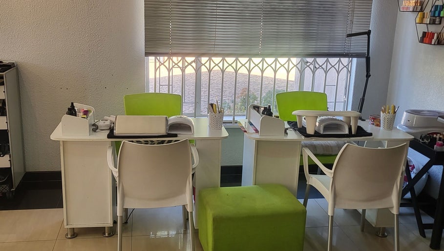 Bright nail stations at Sparkle Nail Studio, Roodepoort, Gauteng, ZA, with green chairs and a scenic view.