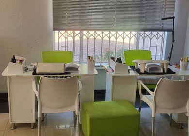 Bright nail stations at Sparkle Nail Studio, Roodepoort, Gauteng, ZA, with green chairs and a scenic view.