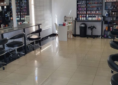 Modern interior of Sparkle Nail Studio in Roodepoort, Gauteng, ZA with sleek black chairs and product shelves.