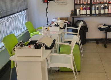Modern nail station at Sparkle Nail Studio, Roodepoort, Gauteng, ZA featuring vibrant green chairs and beauty products.