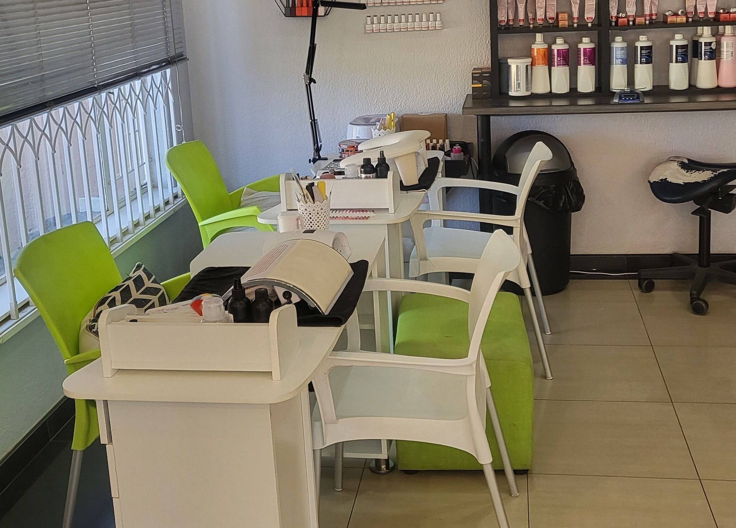 Modern nail station at Sparkle Nail Studio, Roodepoort, Gauteng, ZA featuring vibrant green chairs and beauty products.
