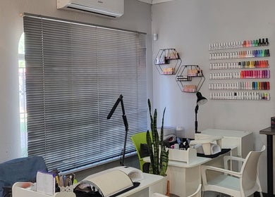 Cozy interior of Sparkle Nail Studio, Roodepoort, Gauteng, ZA, featuring manicure stations and colorful polish display.