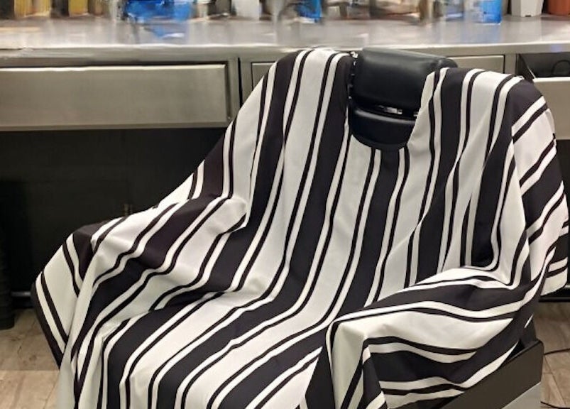 Barber chair with a striped cape at Bmore Barbers Bkk, Krung Thep Maha Nakhon, TH.