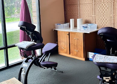 Cozy massage chair setup at Health Care Massage in Bozeman, Montana, US, next to large sunny windows.