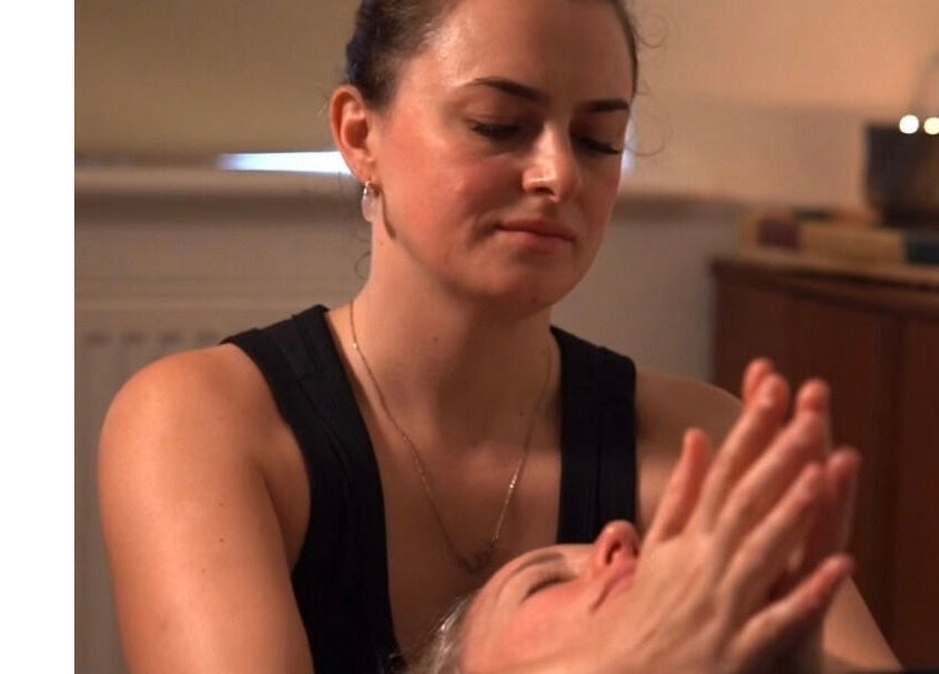 Therapist providing calming massage at Restore With Evie, Chertsey, England, GB in a serene setting.