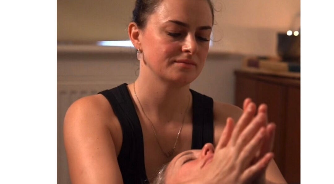 Therapist providing calming massage at Restore With Evie, Chertsey, England, GB in a serene setting.