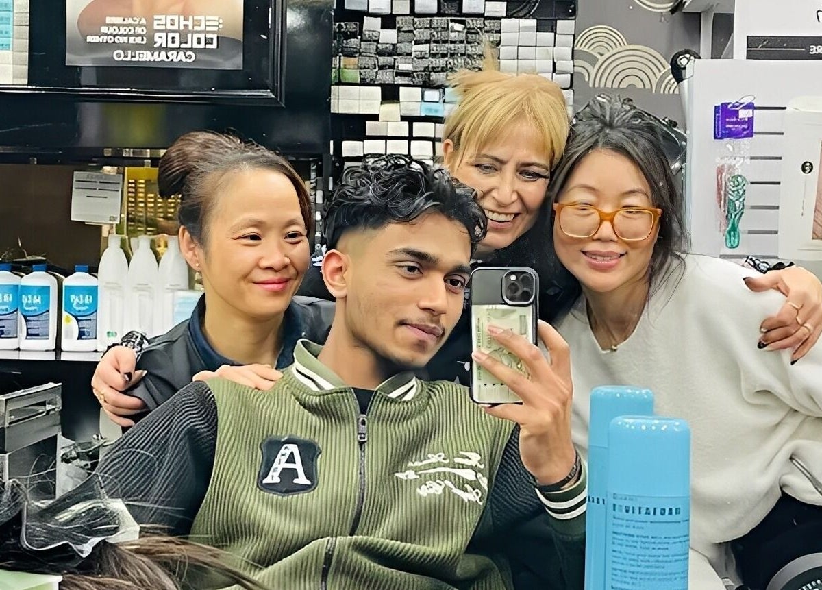 Friendly gathering at Universohair salon in Melbourne, AU, with staff and happy clients around a mirror.