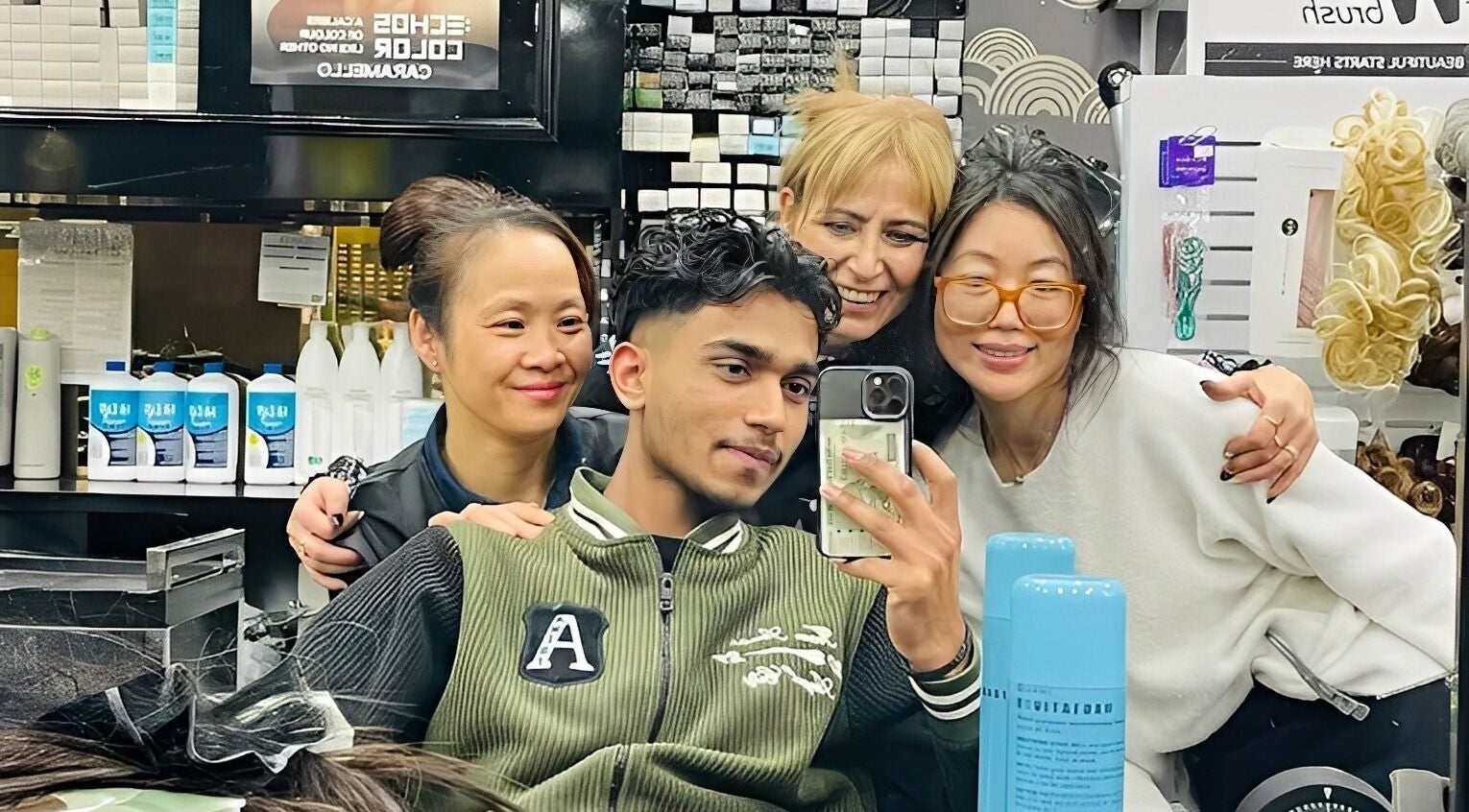 Friendly gathering at Universohair salon in Melbourne, AU, with staff and happy clients around a mirror.