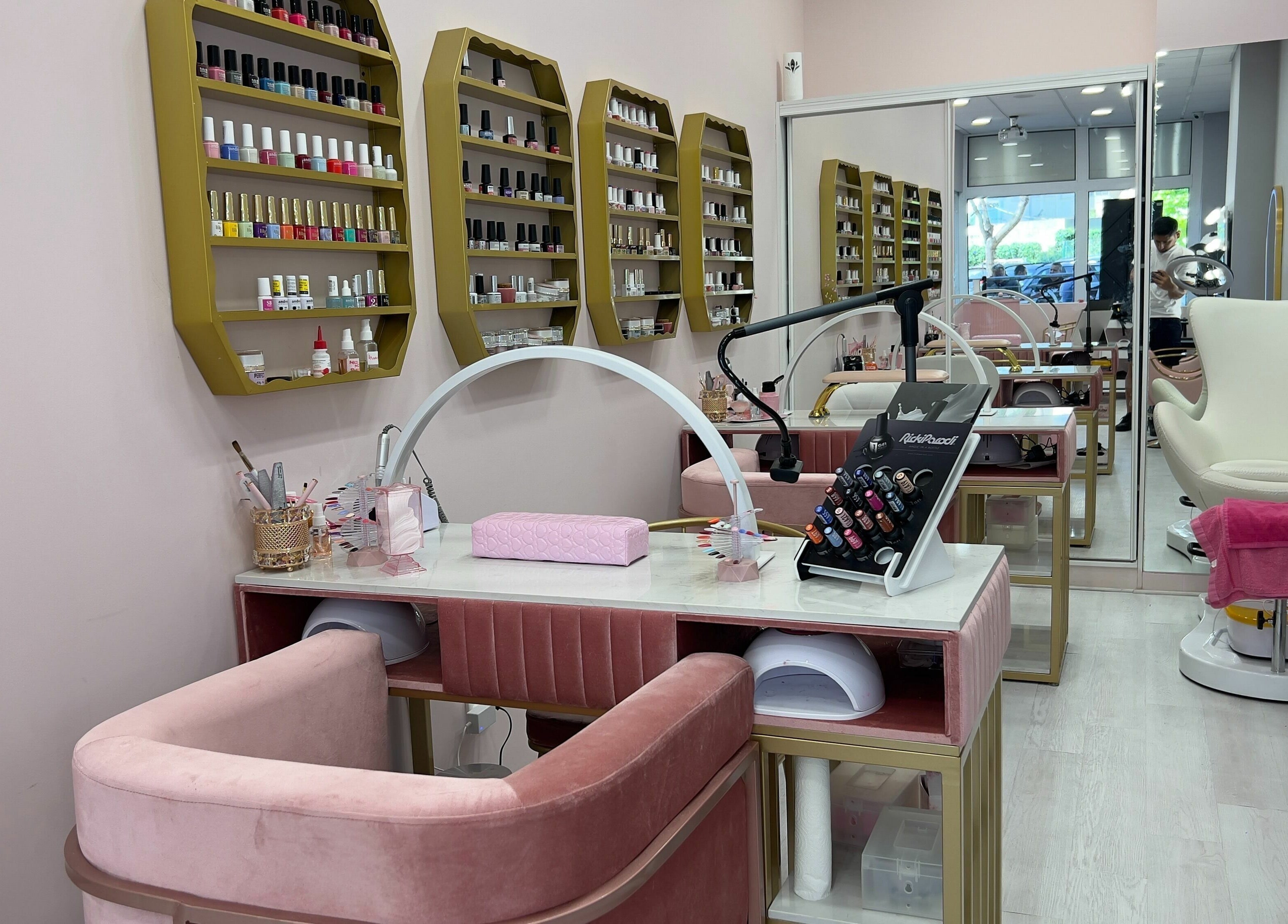 Elegant nail salon at Curls and Glow, Lisboa, Lisboa, PT with plush seating and colorful nail polish display.
