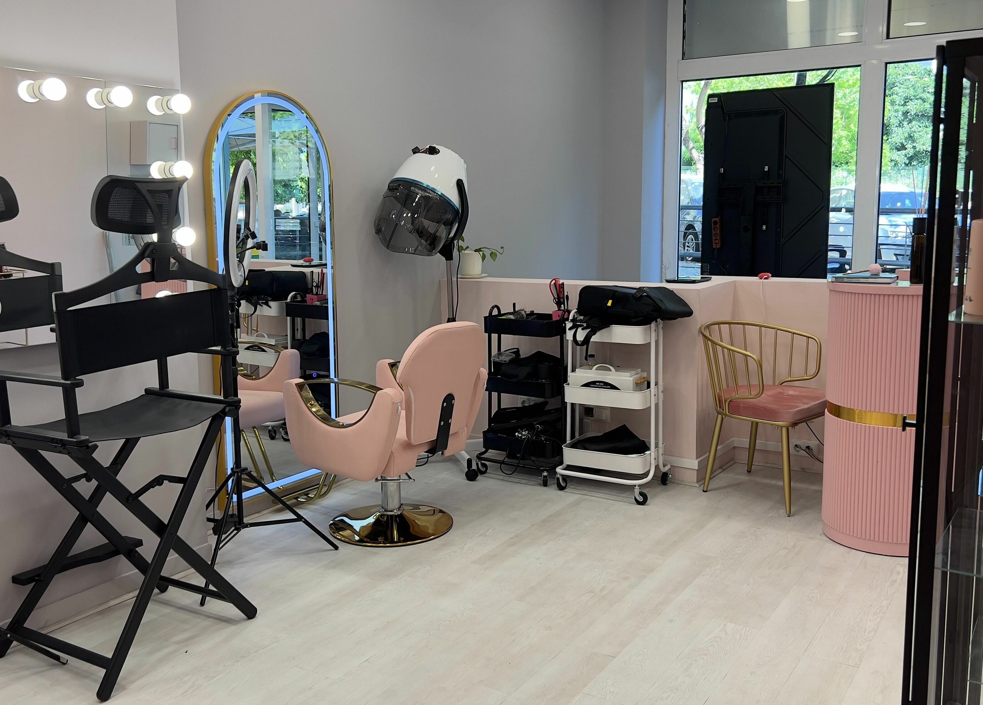 Modern salon interior at Curls and Glow, Lisboa, Lisboa, PT, featuring styling chairs and beauty products.