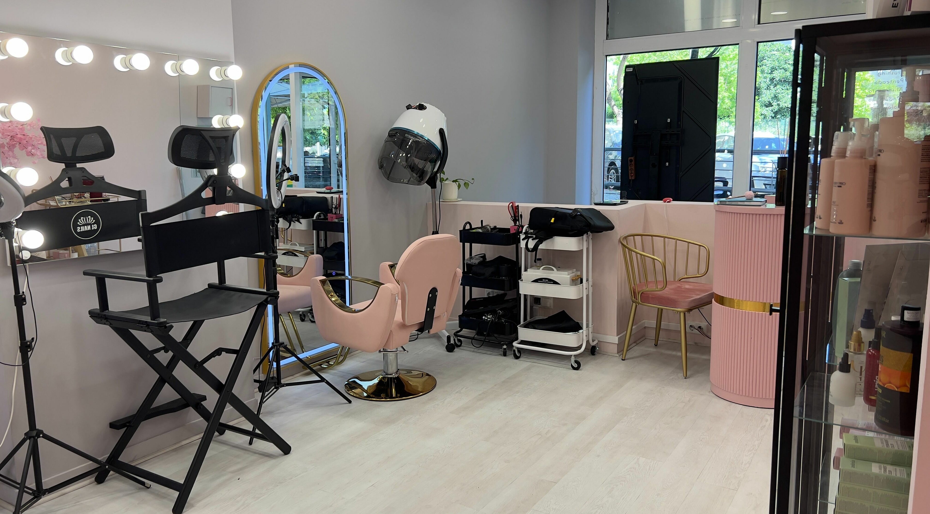 Modern salon interior at Curls and Glow, Lisboa, Lisboa, PT, featuring styling chairs and beauty products.