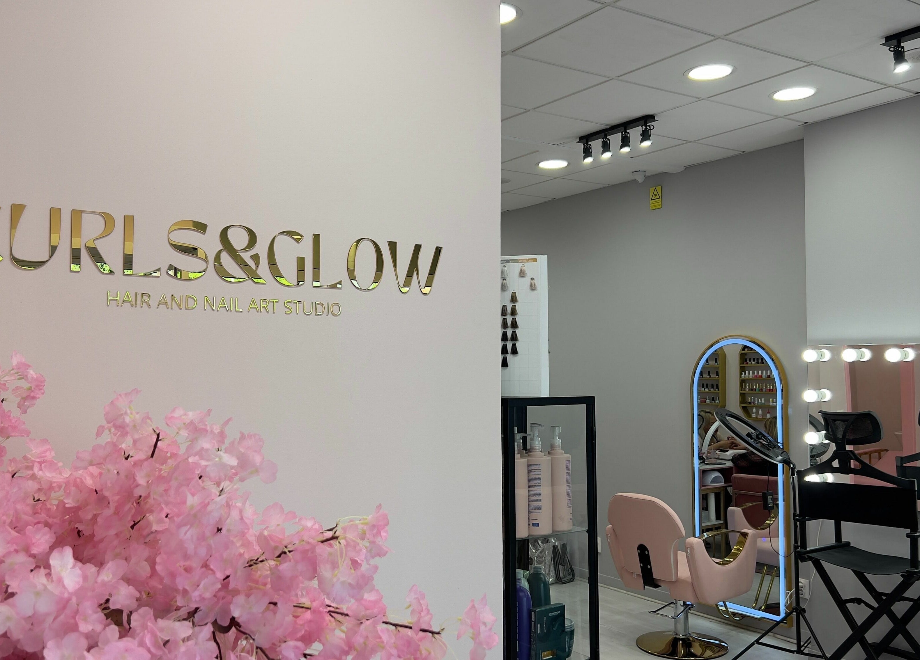 Elegant interior of Curls and Glow salon in Lisboa, Lisboa, PT with pink decor and styling chairs.