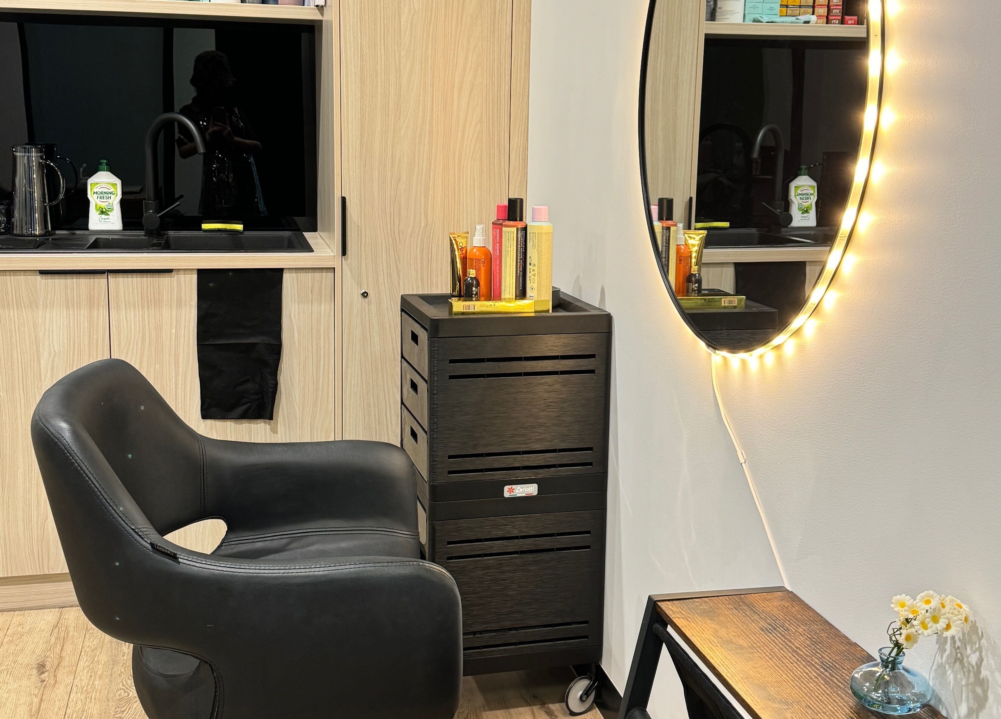 Stylish beauty station at Studio Deja Wu, Melbourne, Victoria, AU featuring a lit mirror and sleek chair.
