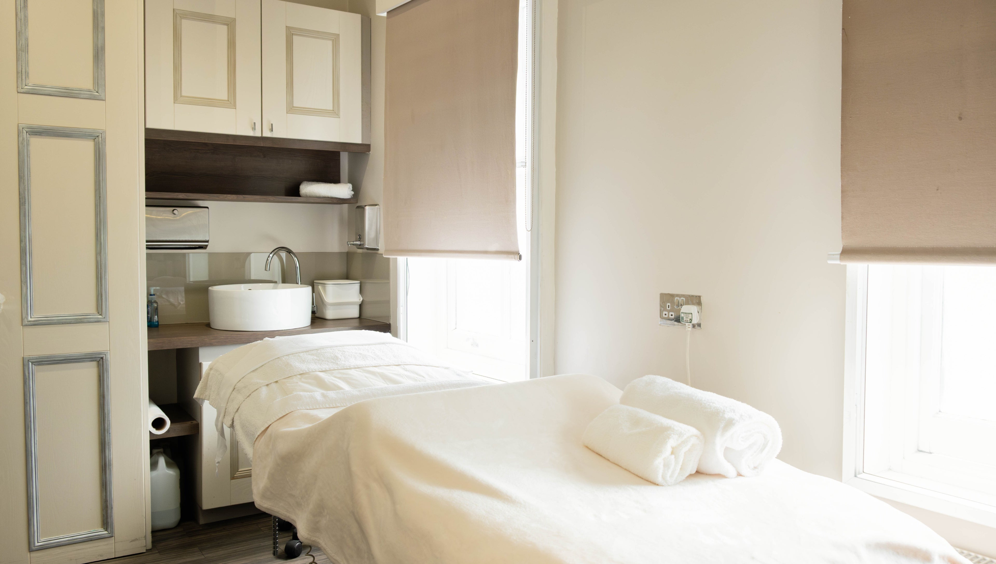 Calm treatment room at Linda Meredith, Knightsbridge in London, England, GB, showcasing a spa bed and sleek decor.
