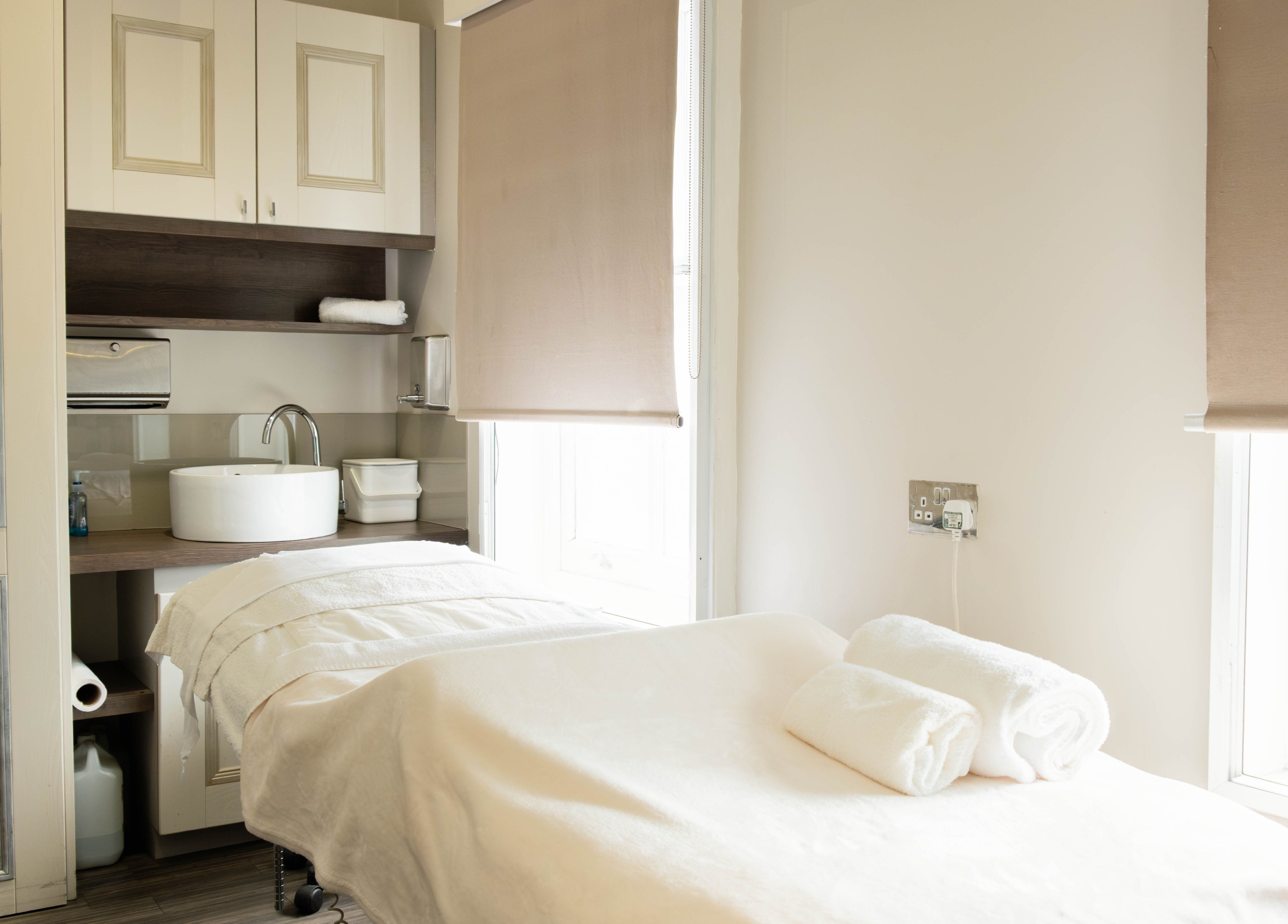Calm treatment room at Linda Meredith, Knightsbridge in London, England, GB, showcasing a spa bed and sleek decor.