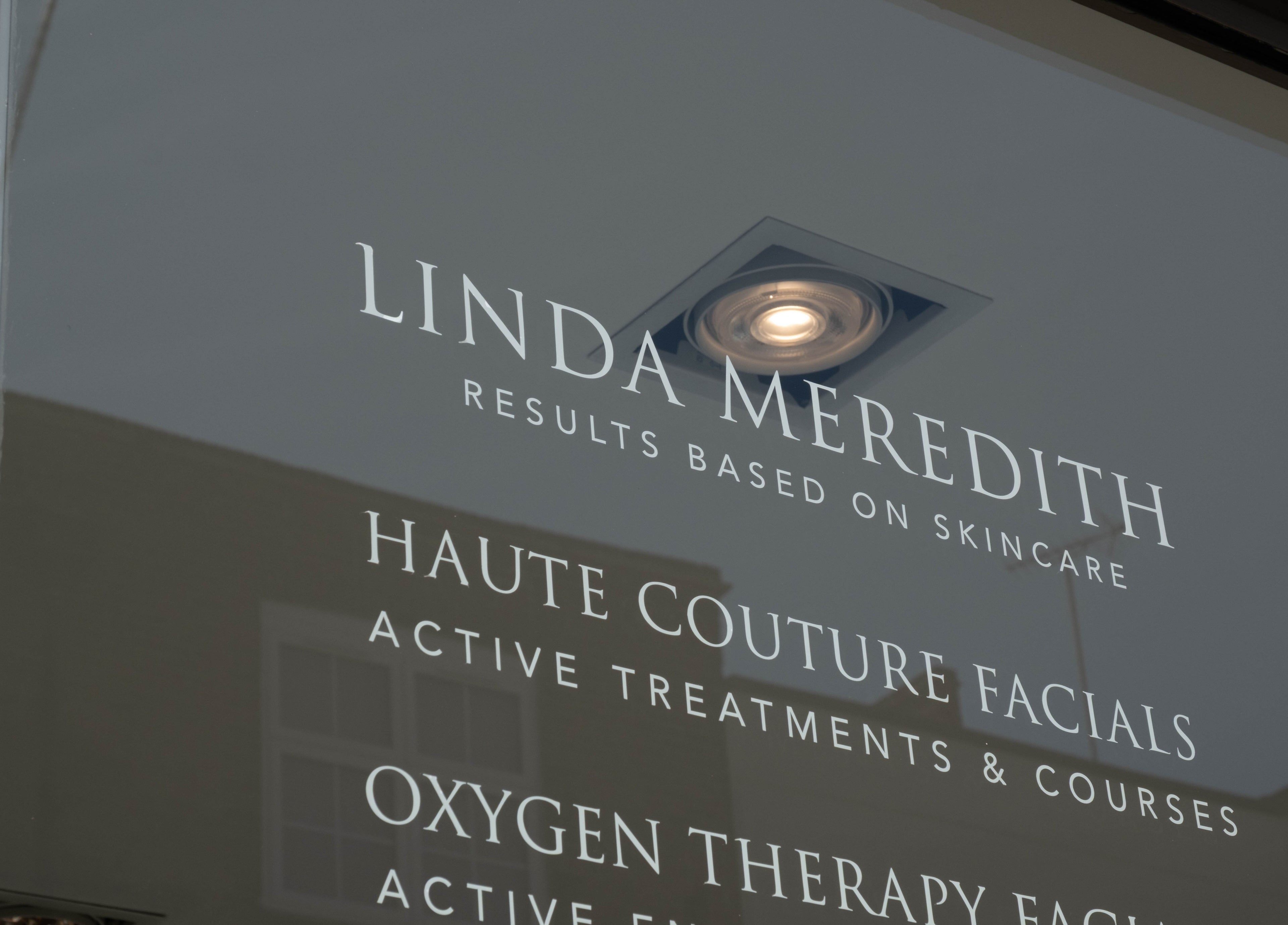 Linda Meredith, Knightsbridge window signage displaying skincare services in London, England, GB.