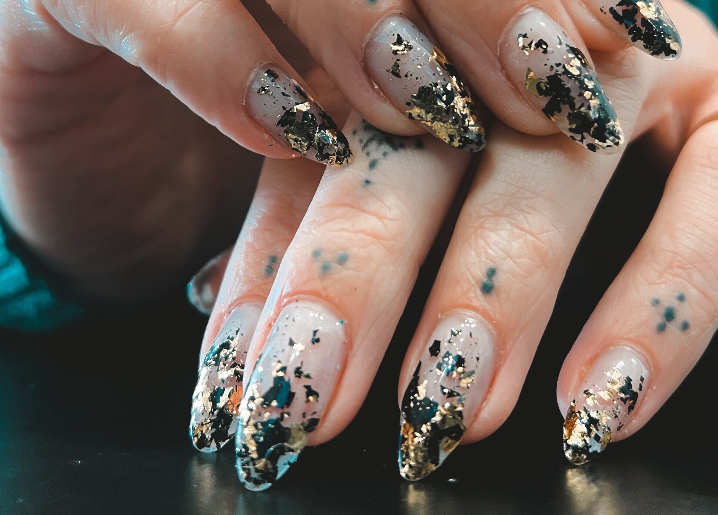 Chic nail art with gold and black flakes at Lada Beauty Studio, Cape Town, Western Cape, ZA.
