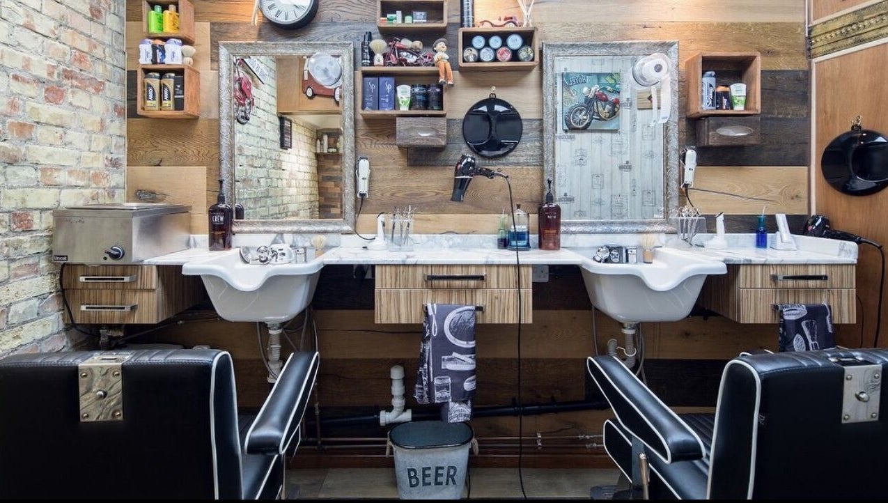 Interior of Pasha Barbers, Bank in London, England, GB showcasing rustic barber chairs and vintage decor.