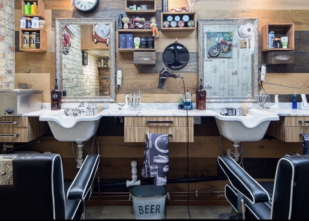 Interior of Pasha Barbers, Bank in London, England, GB showcasing rustic barber chairs and vintage decor.