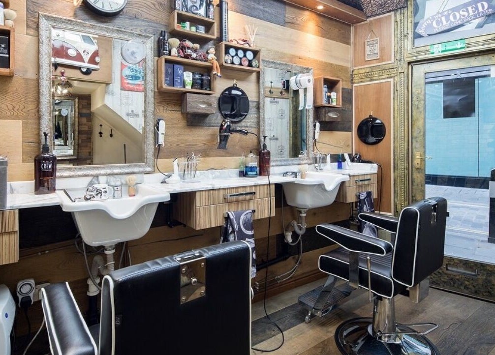 Modern interior of Pasha Barbers, Bank in London, England, GB with stylish chairs and mirrors.