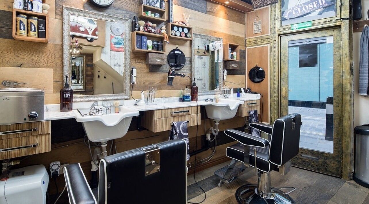 Modern interior of Pasha Barbers, Bank in London, England, GB with stylish chairs and mirrors.