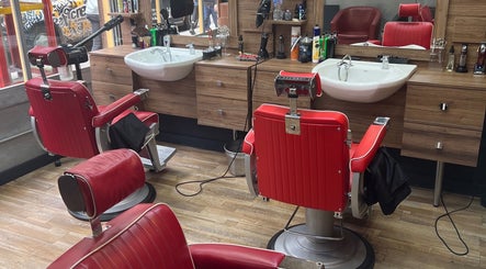 Classic red barber chairs at Pasha Barbers, Liverpool Street, London, England, GB showcasing a sleek interior.