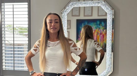 Stylish woman at Permanent Aesthetics Studio, Burton Upon Trent, England, GB, posing by a decorative mirror.
