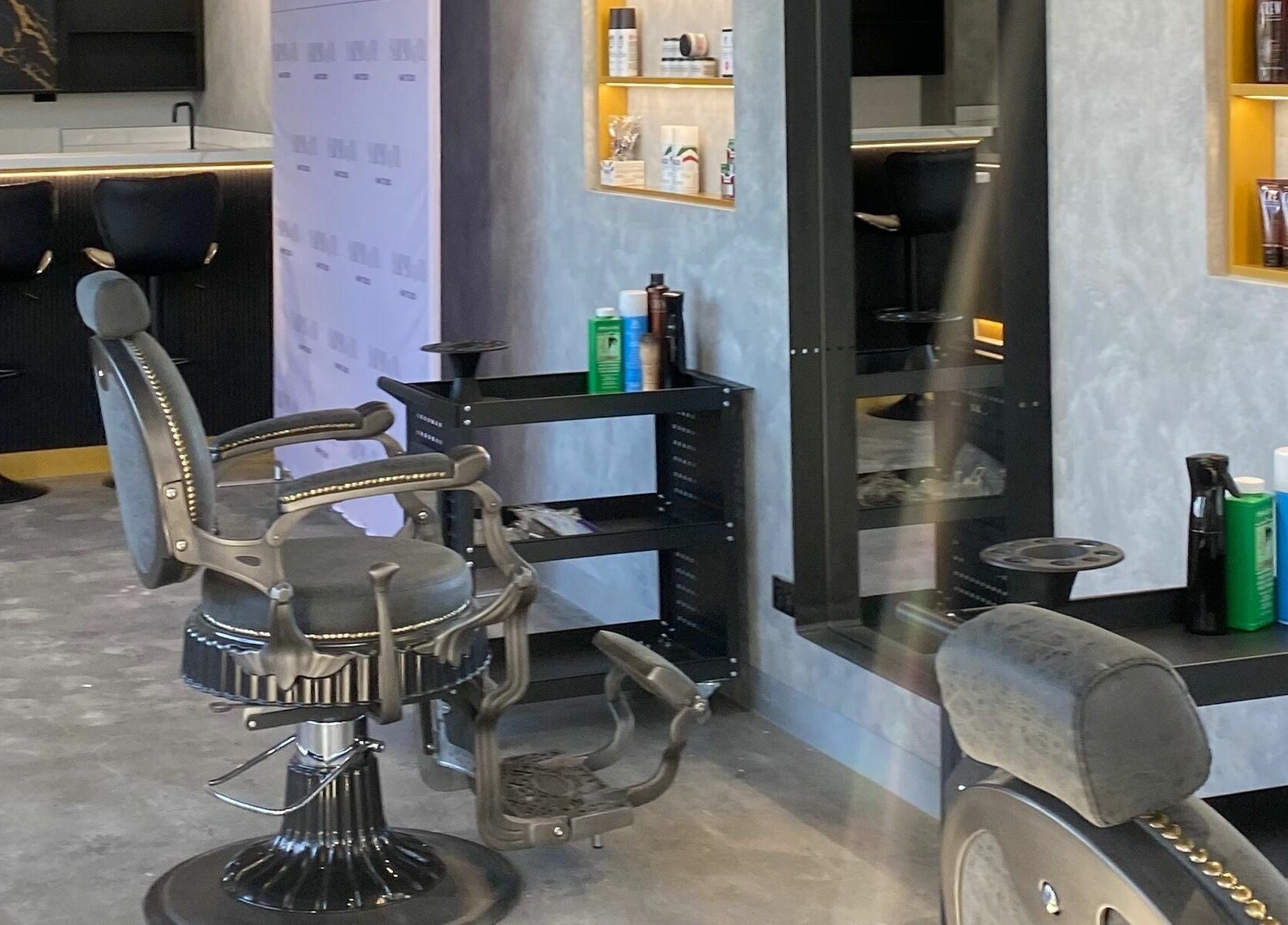 Elegant salon setup at Sarmo & Co., Melbourne, Victoria, AU, featuring stylish black chairs and grooming products.