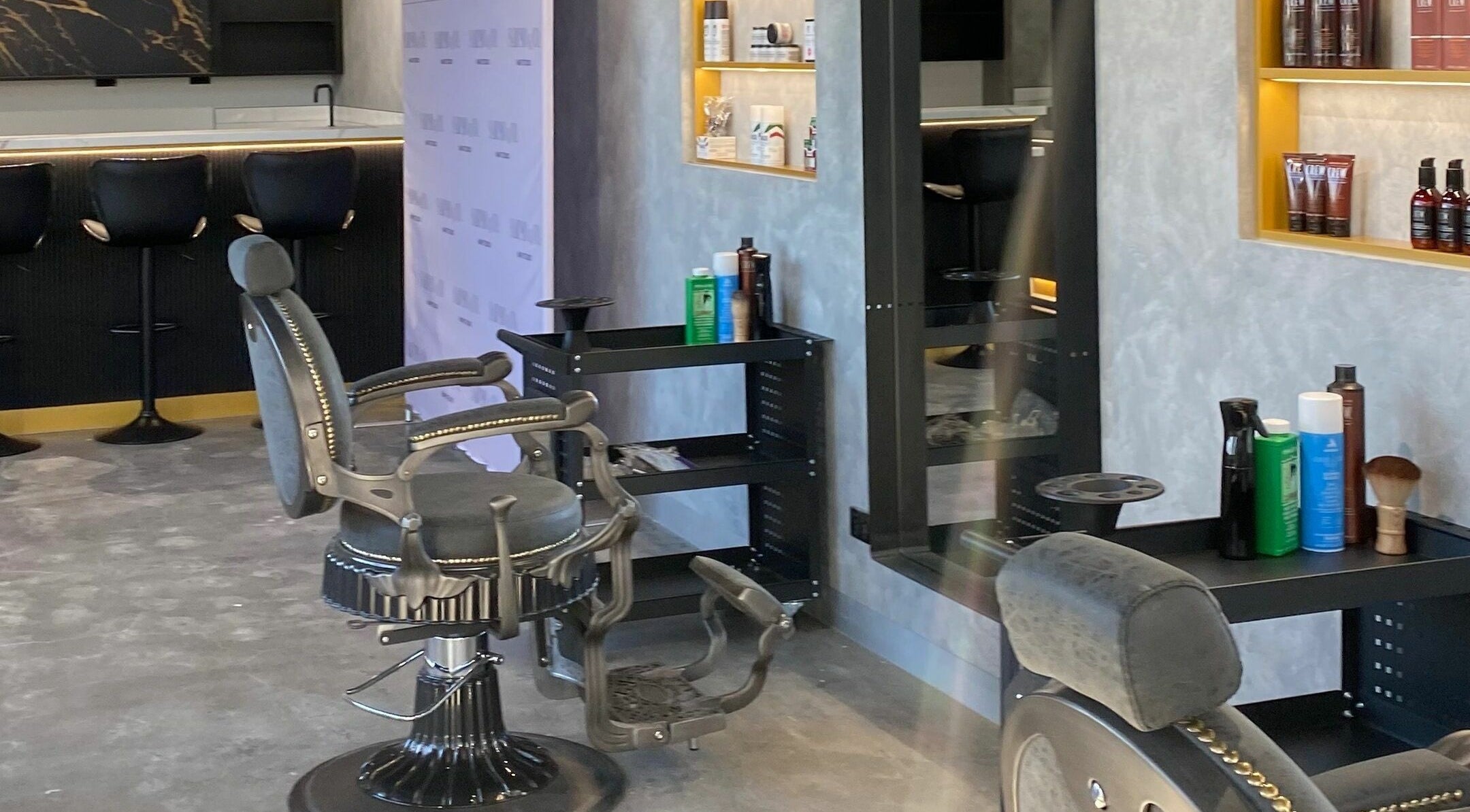 Elegant salon setup at Sarmo & Co., Melbourne, Victoria, AU, featuring stylish black chairs and grooming products.