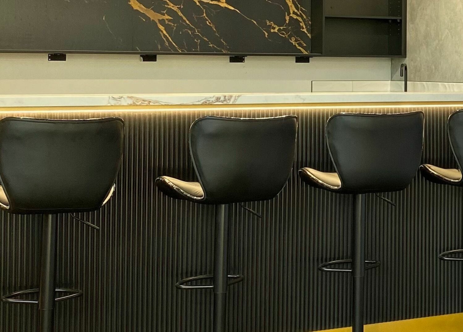 Contemporary seating at Sarmo & Co., Melbourne, Victoria, AU, featuring sleek black chairs and modern decor.
