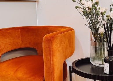 Stylish orange chair and floral decor at Ola’s Studio26, Cheltenham, England, GB.