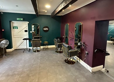 Modern interior of Nuyu Hair & Beauty Salon in Lichfield, England, GB featuring stylish salon chairs and mirrors.