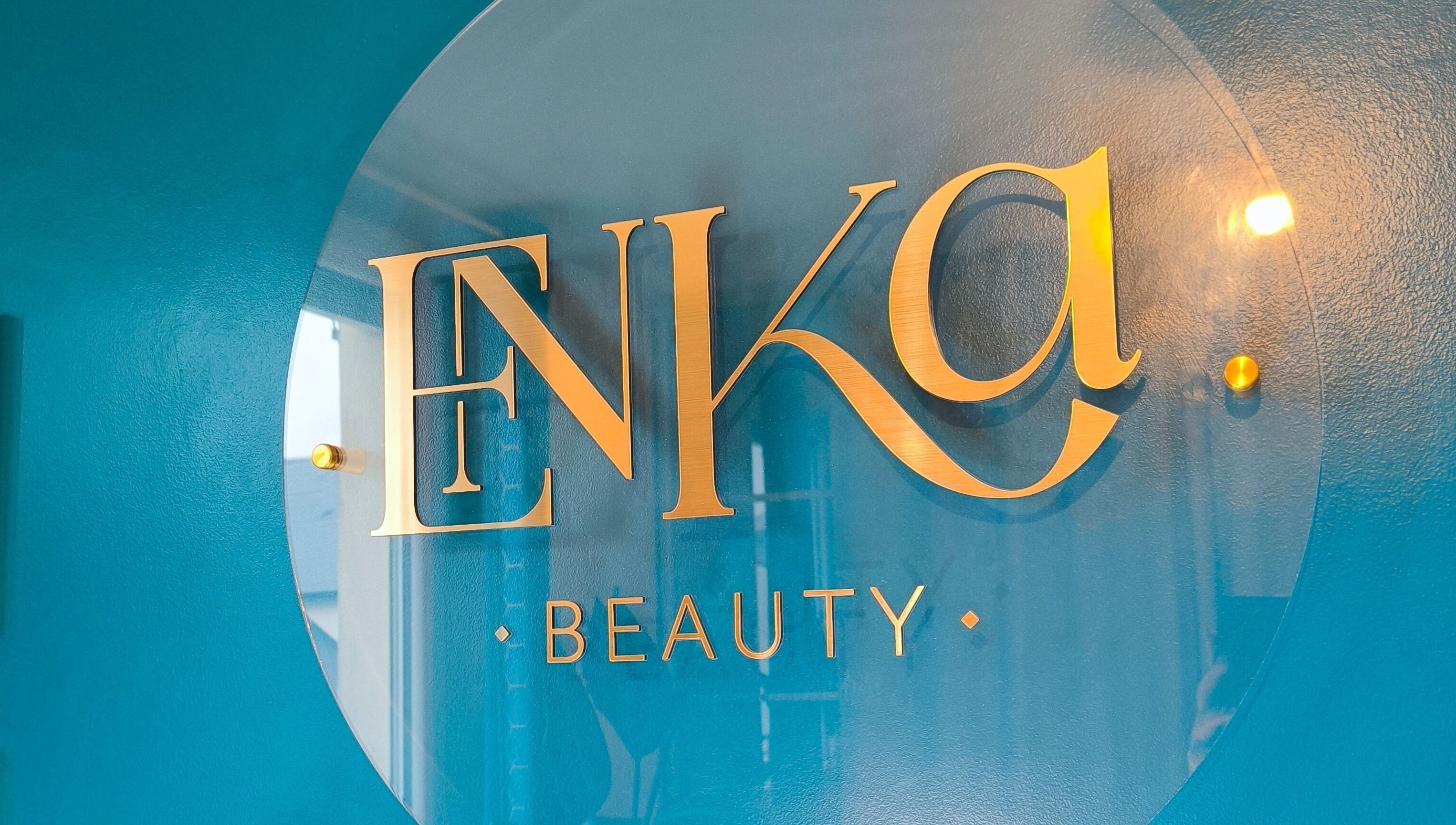 Logo doré d'Enka Beauty sur mur bleu à Orléans, Centre-val De Loire, FR.