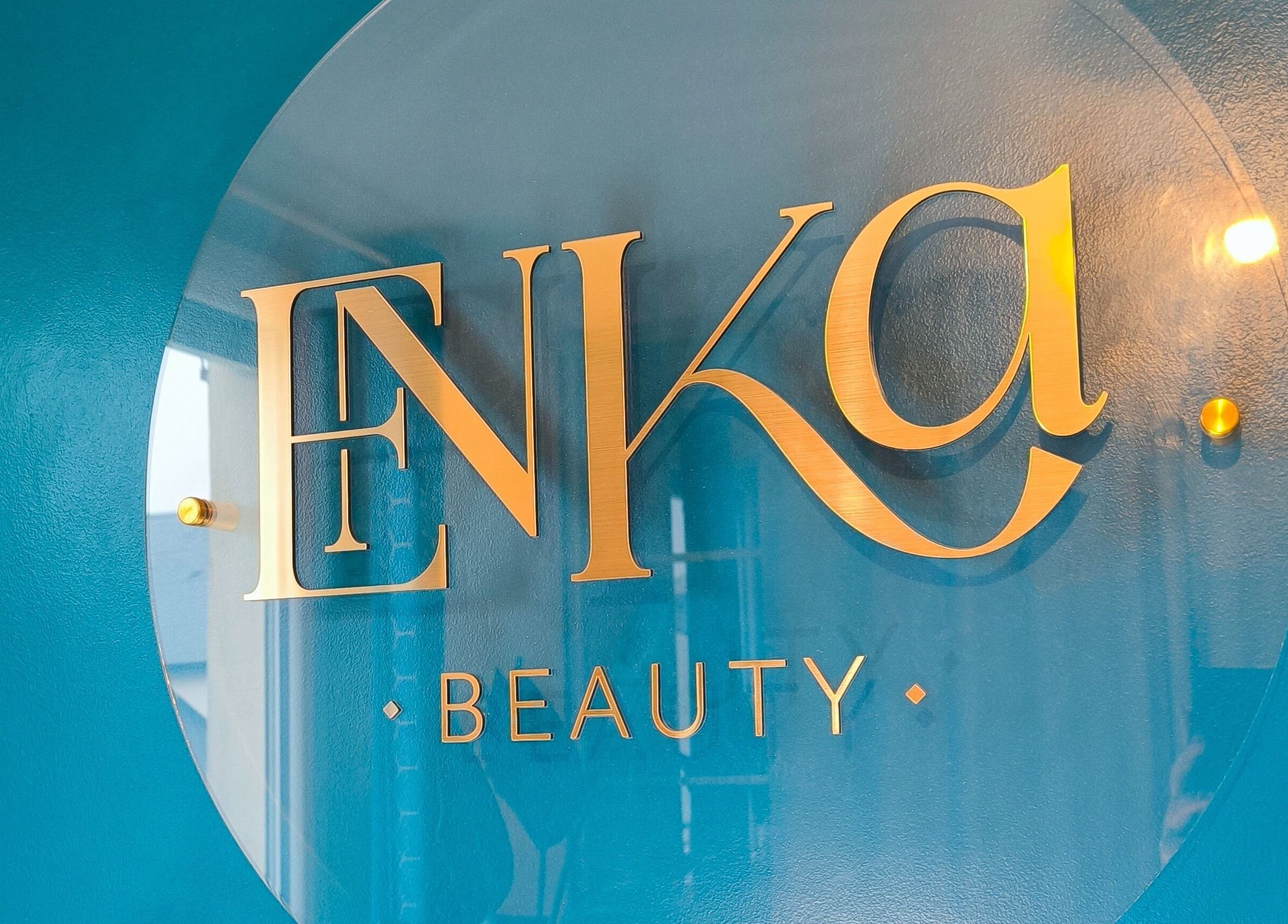 Logo doré d'Enka Beauty sur mur bleu à Orléans, Centre-val De Loire, FR.