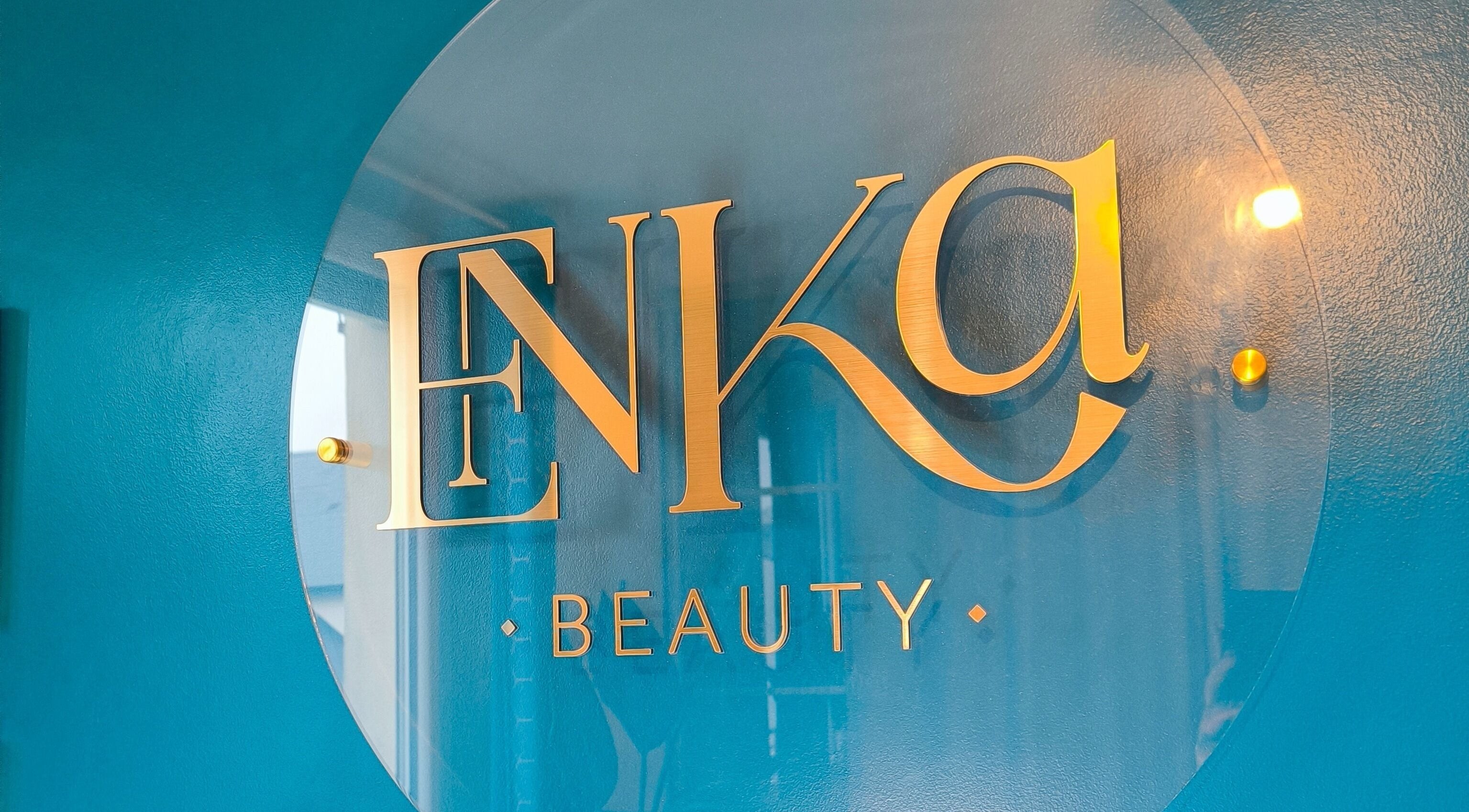 Logo doré d'Enka Beauty sur mur bleu à Orléans, Centre-val De Loire, FR.