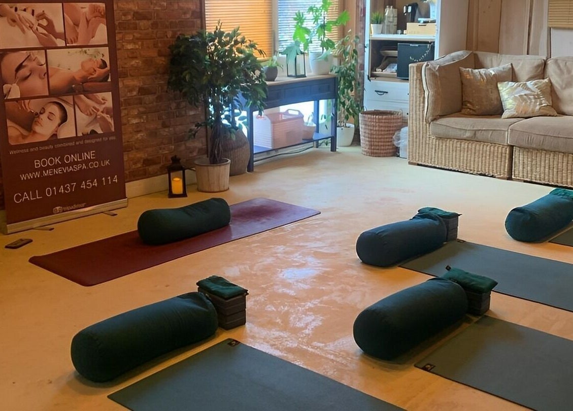 Peaceful yoga space at Menevia Bathhouse and Spa, St Davids, Wales, GB, with mats, cushions, and serene decor.