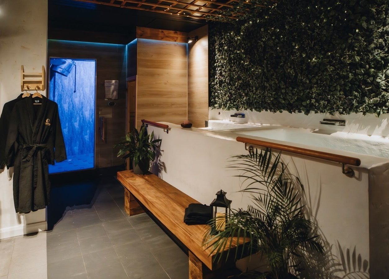 Soothing spa room at Menevia Bathhouse and Spa in St Davids, Wales, GB, featuring a lush green wall and cozy ambiance.
